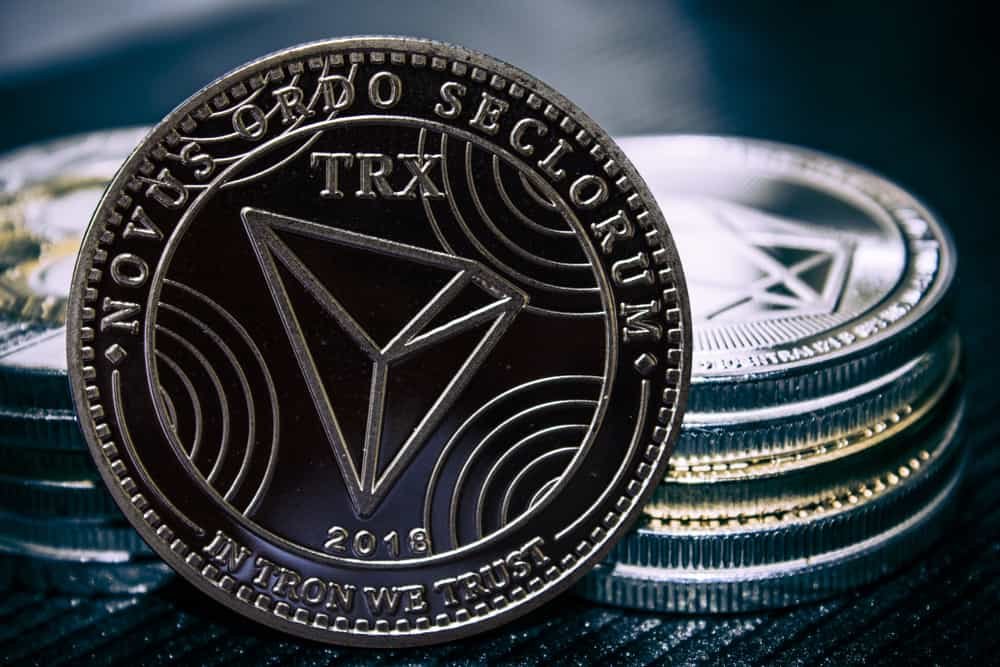 The coin cryptocurrency Tron on the background of a stack of coins.